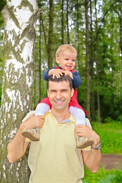 Son sits on shoulders at father — Stock Photo, Image