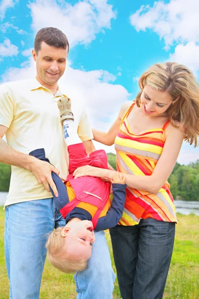 Parents hold child beneath by head — Stock Photo, Image