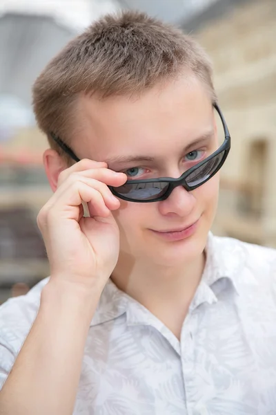 Ung man solglasögon inomhus — Stockfoto