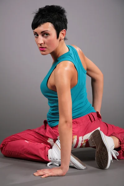 Woman in sportswear sits in lap with side — Stock Photo, Image