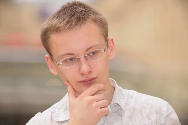 Myšlení mladý muž v brýlích — Stock fotografie