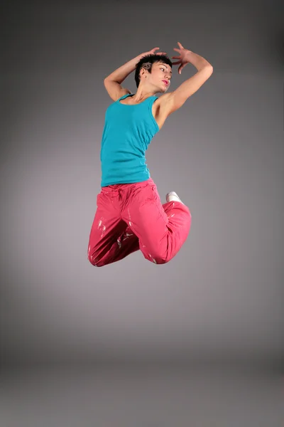 Dancing woman in sportswear jumps — Stock Photo, Image