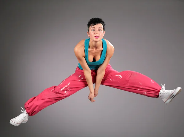 Dancing woman in sportswear jumps — Stock Photo, Image