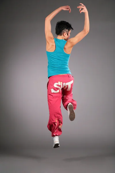 Dansende vrouw in sportkleding springt uit achterkant — Stockfoto