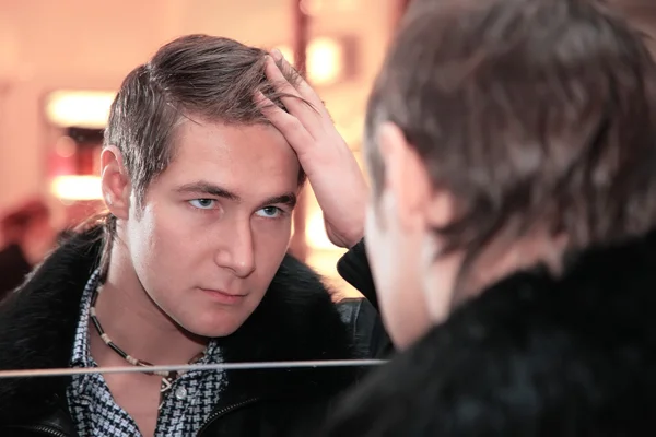 Jonge man kijkt in de spiegel — Stockfoto