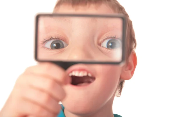 Boy looks through magnifier with surprise — Stock Photo, Image