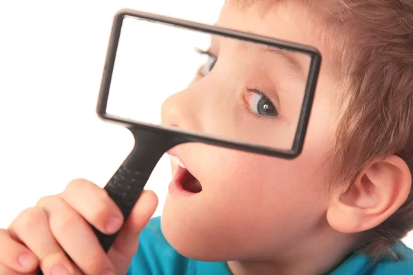 Boy looks through magnifier with interest — Stock Photo, Image