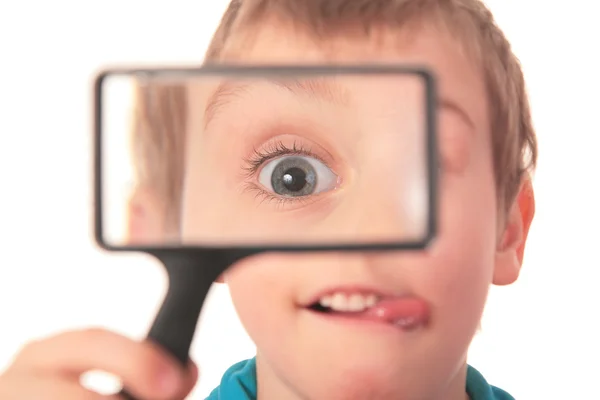 Boy looks through magnifier with interest — Stock Photo, Image