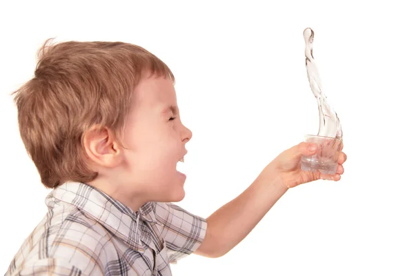 Boy spills water from glass — Stock Photo, Image