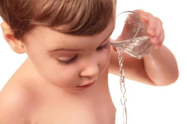小さな子供がガラスから水を注ぐ — ストック写真