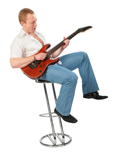 Молодой человек с гитарой на стуле — стоковое фото