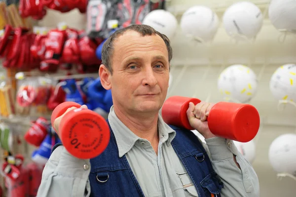 Άνθρωπος με αλτήρες στο κατάστημα του αθλητισμού — Φωτογραφία Αρχείου