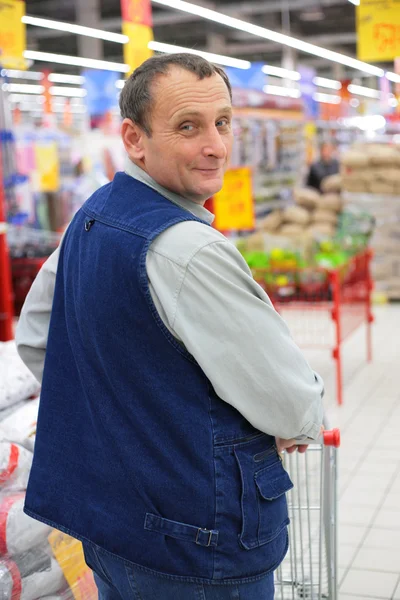 Muž v supermarketu s nákupní košík — Stock fotografie
