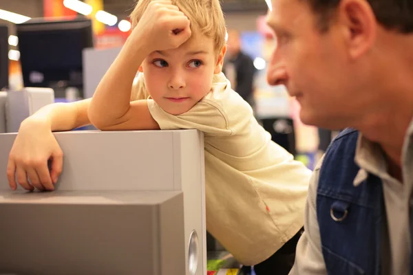 Мальчик смотрит на мужчину в магазине — стоковое фото