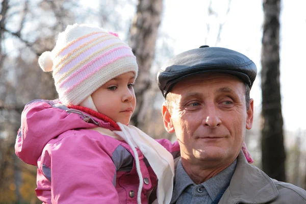 Grandfather with granddaughter on hands outdoor — Stock Photo, Image