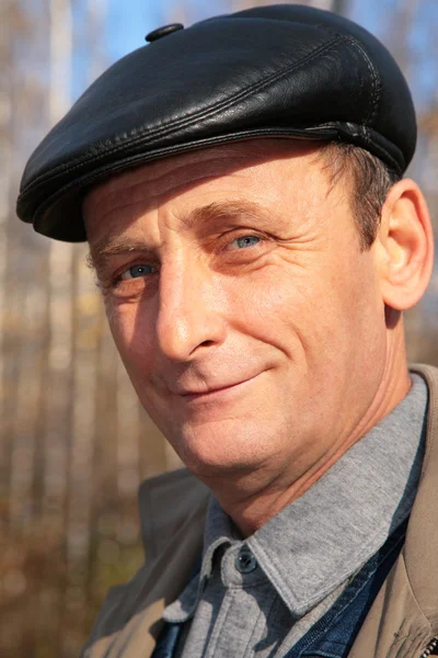 Portret starszego mężczyzny w czarny kapelusz z drewna w jesieni — Zdjęcie stockowe
