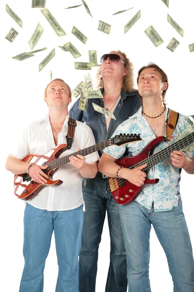 Tre uomini con due chitarre guardano ai dollari che cadono — Foto Stock