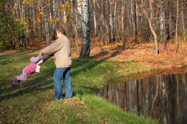 Dědeček se otáčí vnučka v lese na podzim — Stock fotografie