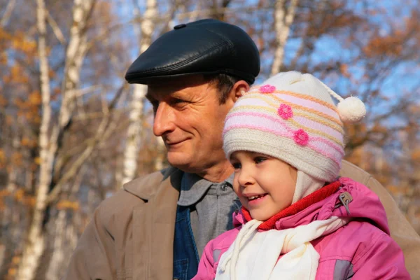 Portrait of grandfather with granddaughter in wood in autumn — Stock Photo, Image