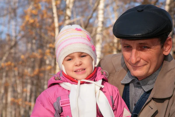 Портрет дедушки с внучкой в лесу осенью — стоковое фото