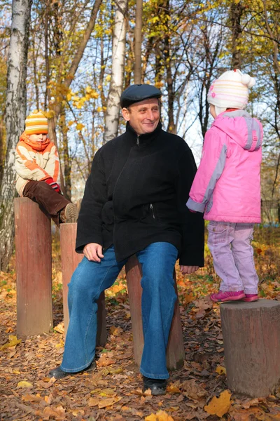Abuelo con nietos en el bosque en otoño — Foto de Stock