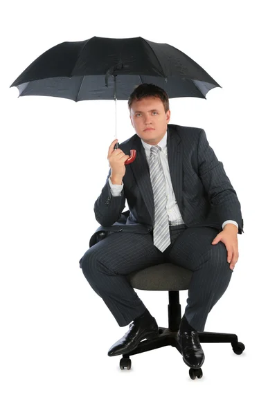 Businessman on chair with umbrella — Stock Photo, Image