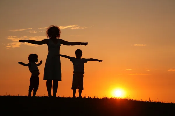 Moeder en kinderen op zonsondergang — Stockfoto