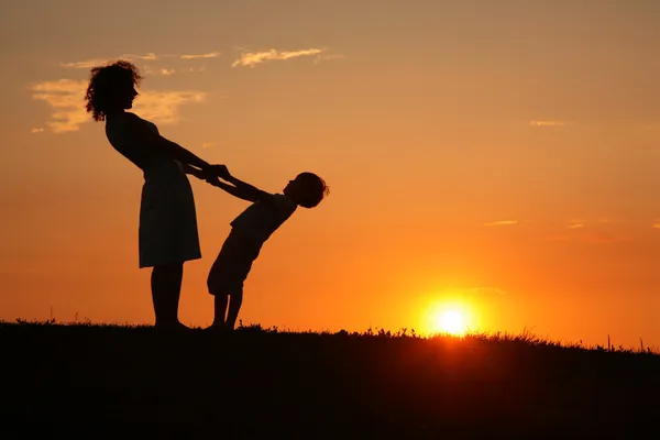 Anne ve oğlu günbatımı üzerinde — Stok fotoğraf