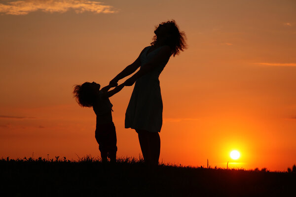 Mother and daughter on sunset