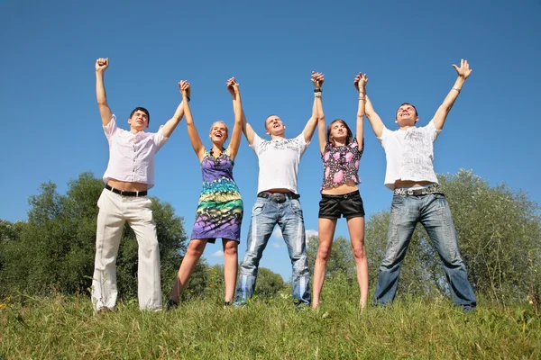 Grupo de amigos com mãos levantadas ao ar livre no verão — Fotografia de Stock