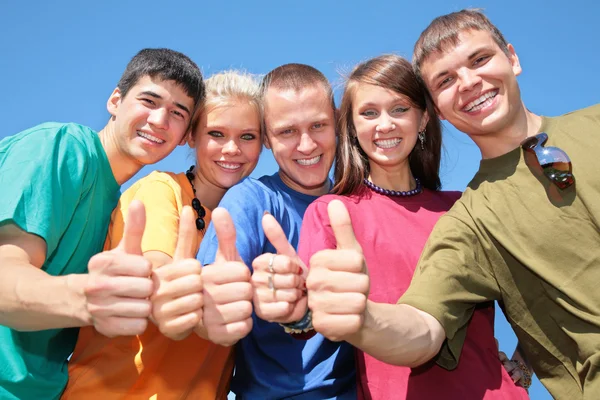 Group of friends in multicolor shirts make gestures by fingers — Stock Photo, Image