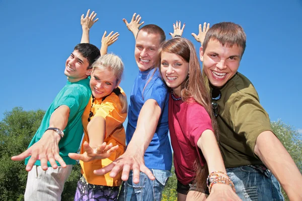 Grupo de amigos en camisas multicolores hacen gestos con las manos — Foto de Stock