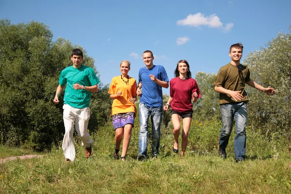Grupp vänner i multicolor skjortor körs — Stockfoto