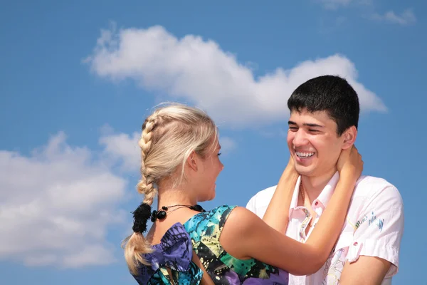 Girl embraces guy for neck on sky background — Stock Photo, Image
