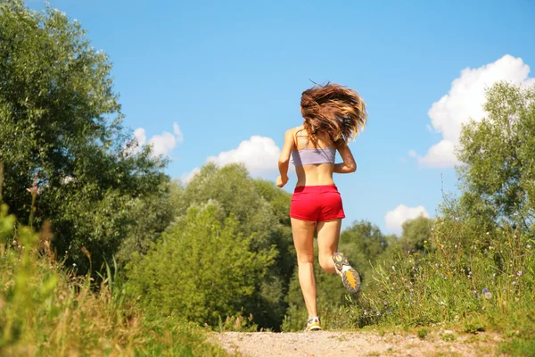 Девушка бежит в лесу со спины — стоковое фото