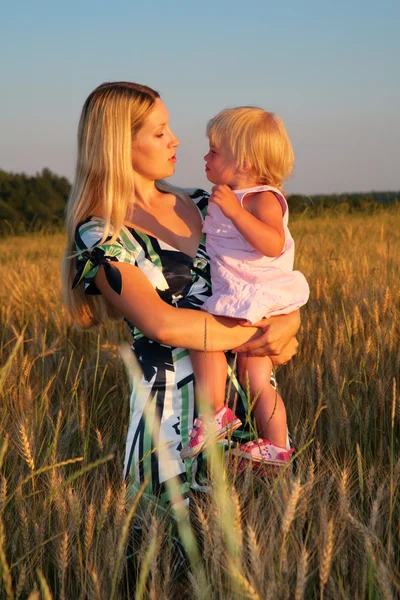 La madre tiene il bambino sulle mani nel campo di grano — Foto Stock