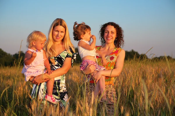 Zwei Mütter mit Kindern auf einem Weizenfeld — Stockfoto