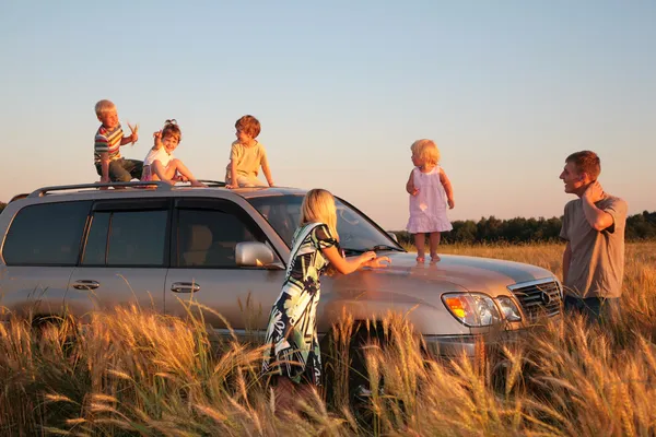 Parents and children on offroad car on wheaten field — Stock Photo, Image