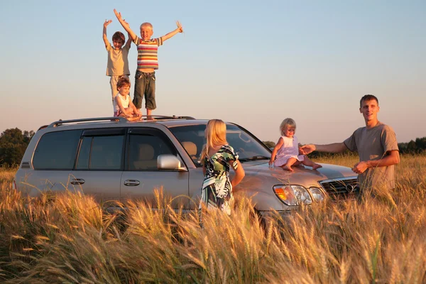 Parents and children on offroad car on wheaten field — Stock Photo, Image