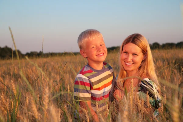 Mother and son on wheaten field — Stock Photo, Image
