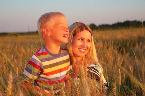 Anne ve oğlu buğday alanında oturup — Stok fotoğraf