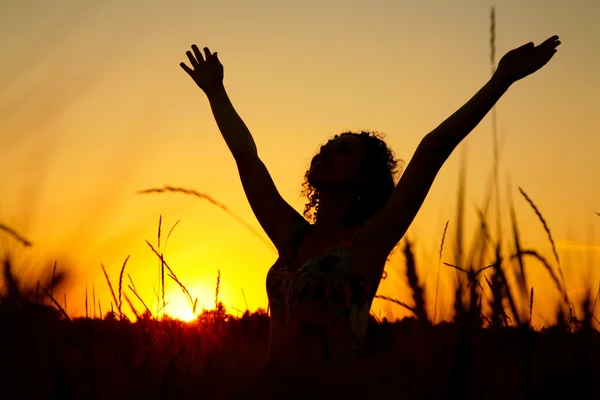 Silhouette féminine au coucher du soleil sur champ de blé — Photo