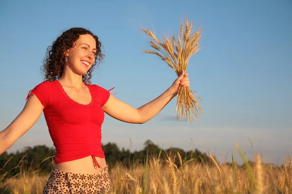 Young woman with earns on wheaten field — Stock Photo, Image