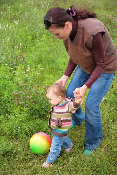 Мати і дитина грають з м'ячем на траві — стокове фото