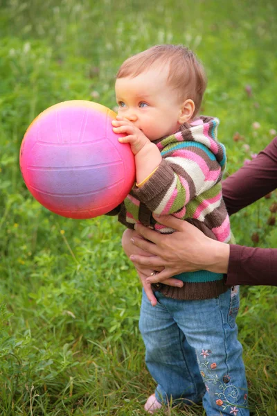 Mamma håller barnet med boll — Stockfoto