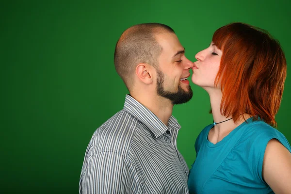 Girl with red hair kisses guy on nose — Stock Photo, Image