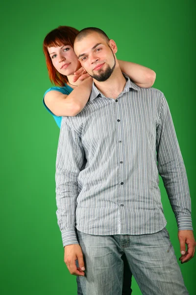 Девушка с рыжими волосами обнимает парня сзади — стоковое фото
