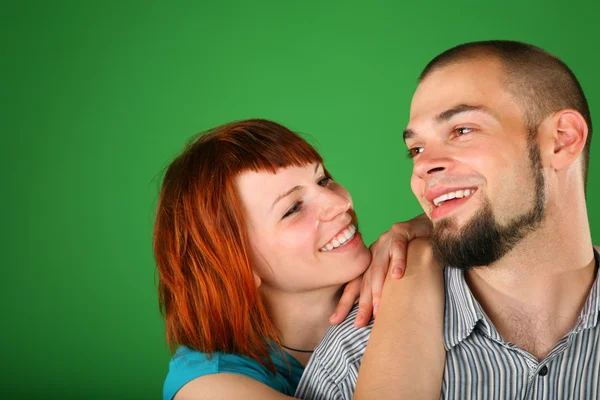 Girl with red hair embraces guy for shoulder — Stock Photo, Image