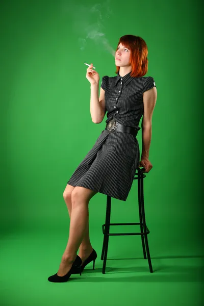Κορίτσι με τα κόκκινα μαλλιά καπνίζει, κάθεται στο σκαμνί — Φωτογραφία Αρχείου
