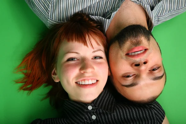 Girl with red hair and guy lie head to head — Stock Photo, Image